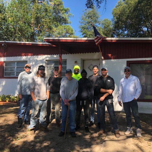Southern Coast Roofing crew with a Rooftops for Heroes recipient at his home